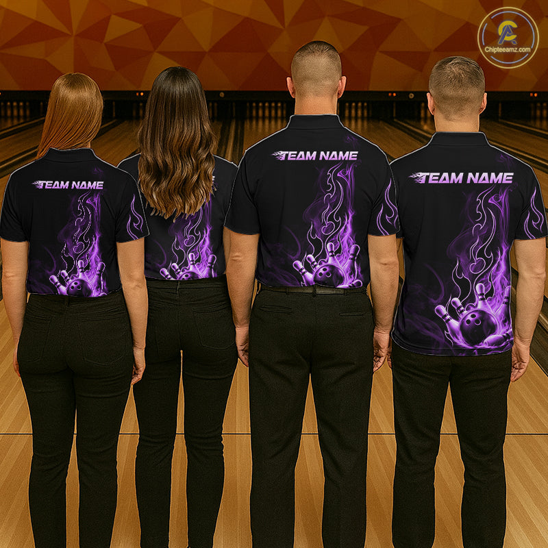 Four people standing in a bowling alley, viewed from behind, wearing matching black short-sleeve shirts with purple flame graphics and white 'TEAM NAME' text on the back.