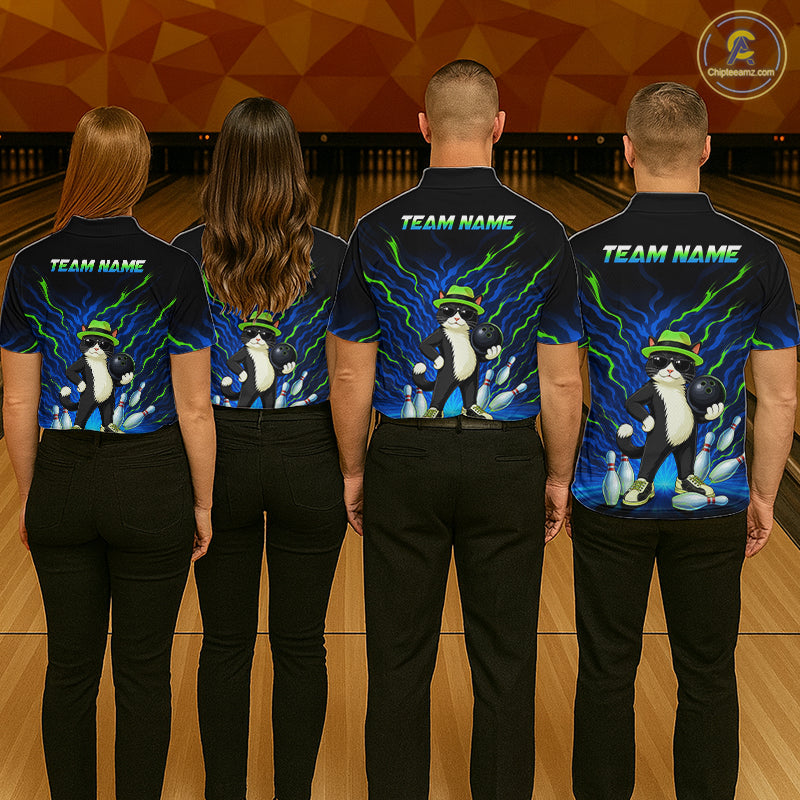 Four people standing with their backs to the camera in a bowling alley, wearing matching dark navy short-sleeve shirts with a colorful cartoon penguin graphic and 'TEAM NAME' text on the back, paired with black pants.