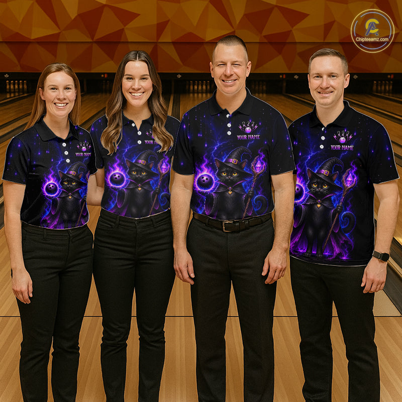 Four people standing in a bowling alley wearing matching black short-sleeve polo shirts with a purple and black cosmic cat graphic on the front. 