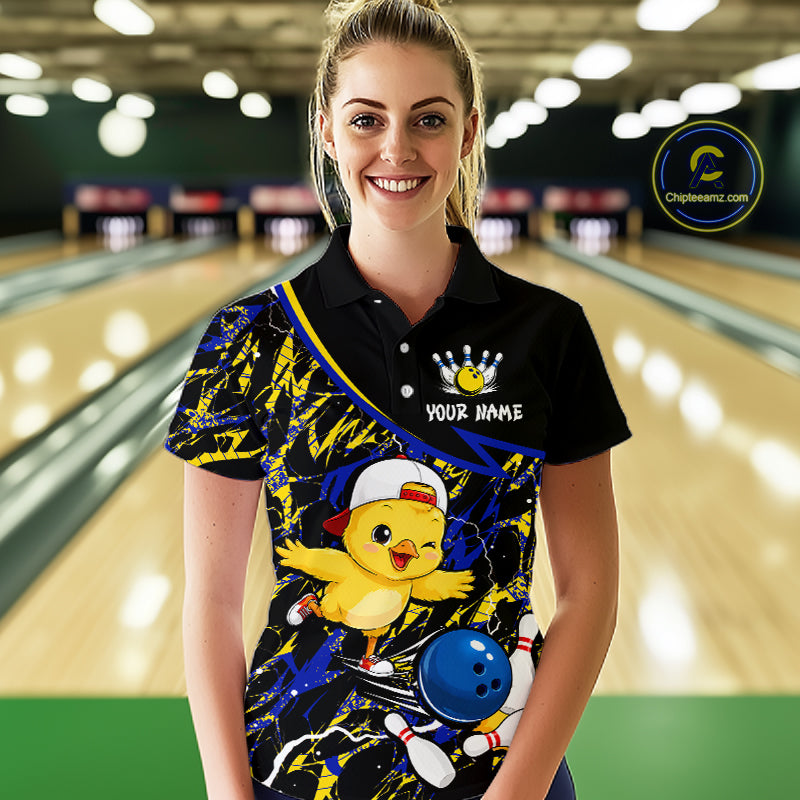 Person wearing a colorful bowling shirt with a cartoon character in a bowling alley.