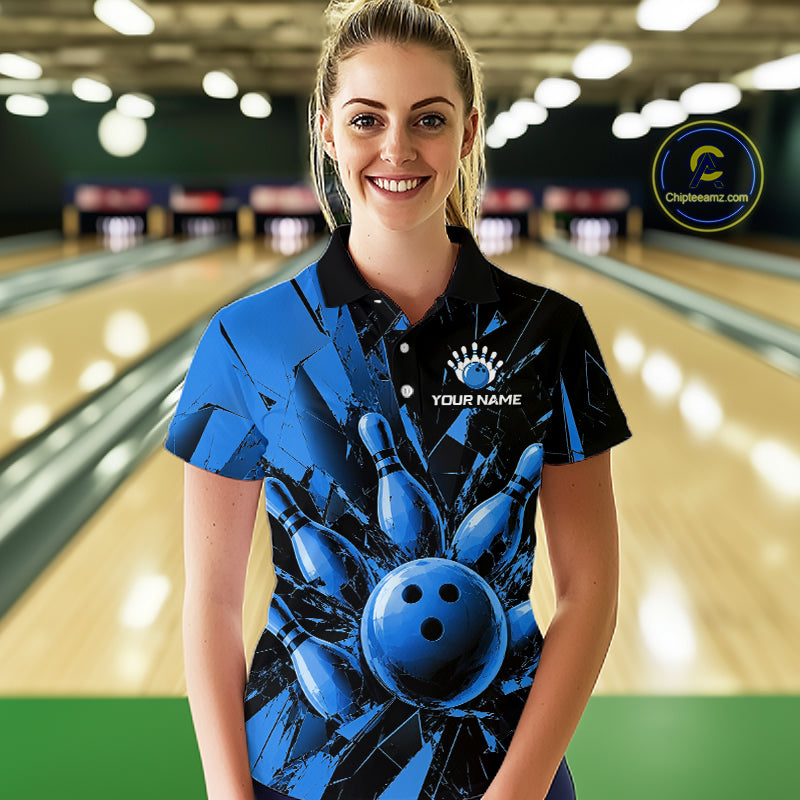 A woman stands in a bowling alley wearing a custom blue and black bowling-themed polo shirt with a bowling pin and ball graphic, and a white placeholder logo on the chest.