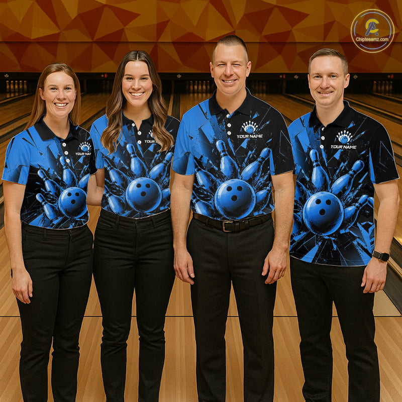 Four people standing together in a bowling alley wearing matching blue and black short-sleeve bowling shirts with a large blue bowling ball graphic on the front, paired with black pants. A bowling lane and orange geometric wall are visible in the background.
