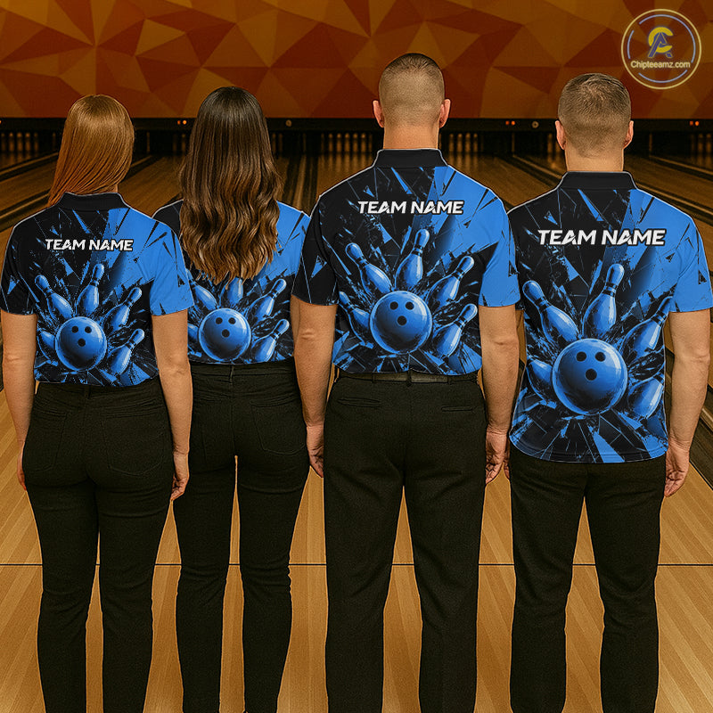 Four people standing in a bowling alley, viewed from behind, wearing matching blue bowling-themed short-sleeve shirts with black pants. The shirts feature a large blue bowling ball and pins graphic on the back with 'TEAM NAME' printed in white.