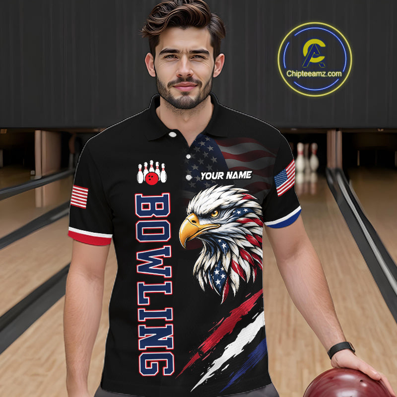 Man wearing a black bowling shirt with an eagle design in a bowling alley.