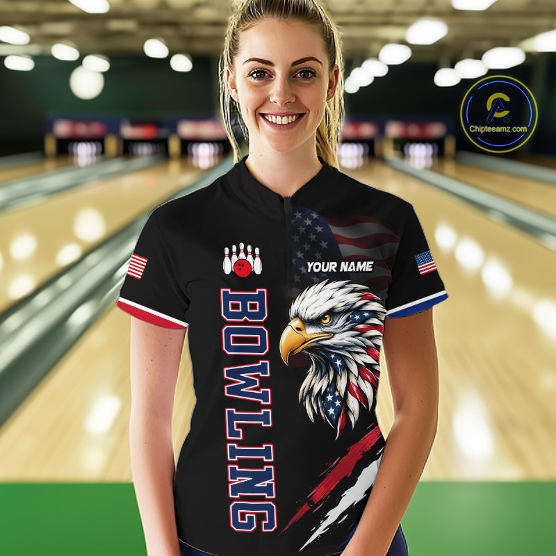 Person wearing a black bowling shirt with an eagle design and 'Bowling' text in a bowling alley.