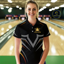 Load image into Gallery viewer, Woman wearing a black bowling shirt with a logo and text in a bowling alley.
