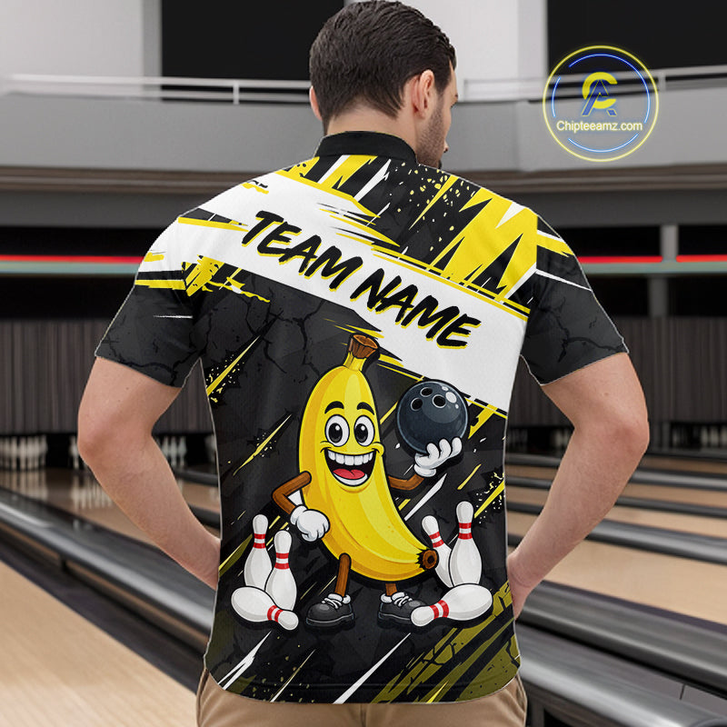 Man wearing a bowling-themed shirt with a cartoon banana character in a bowling alley.