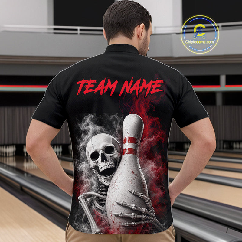 A man viewed from behind wearing a black short-sleeve bowling shirt with a large back graphic showing a skull, skeleton hand, bowling pin, red smoke, and the text 'TEAM NAME' in red. The background is a bowling alley, and a 'Chipteeamz'.