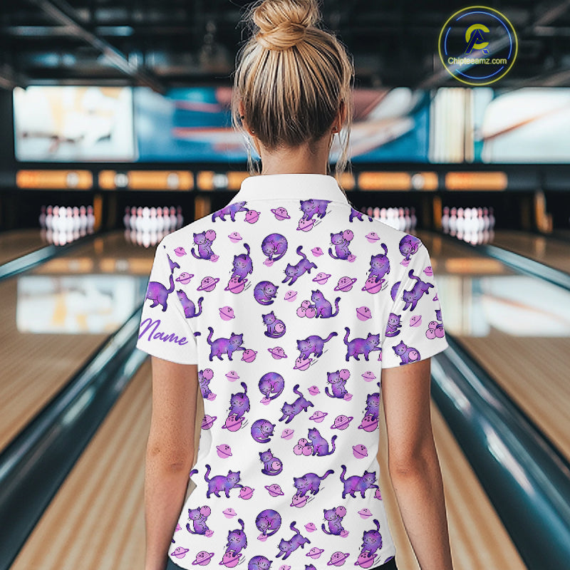 Woman wearing a white shirt with purple cat pattern in a bowling alley.