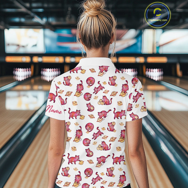 Women wearing a colorful shirt with cat patterns in a bowling alley.
