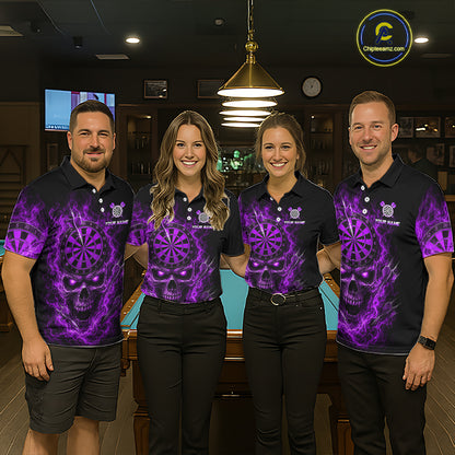 Four people standing together in a bar or lounge setting, wearing matching black polo shirts with a vivid purple skull and dartboard graphic print. The shirts also feature a small crest logo and the text 'YOUR NAME' and 'TEAM NAME'.