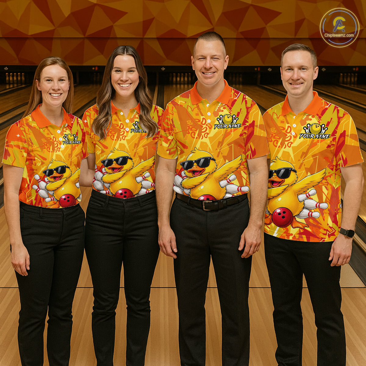 Four people wearing matching orange and yellow bowling shirts with cartoon characters in a bowling alley.