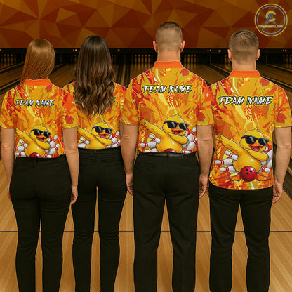 Four people wearing matching bowling shirts with a duck graphic and 'Team Name' text in a bowling alley.