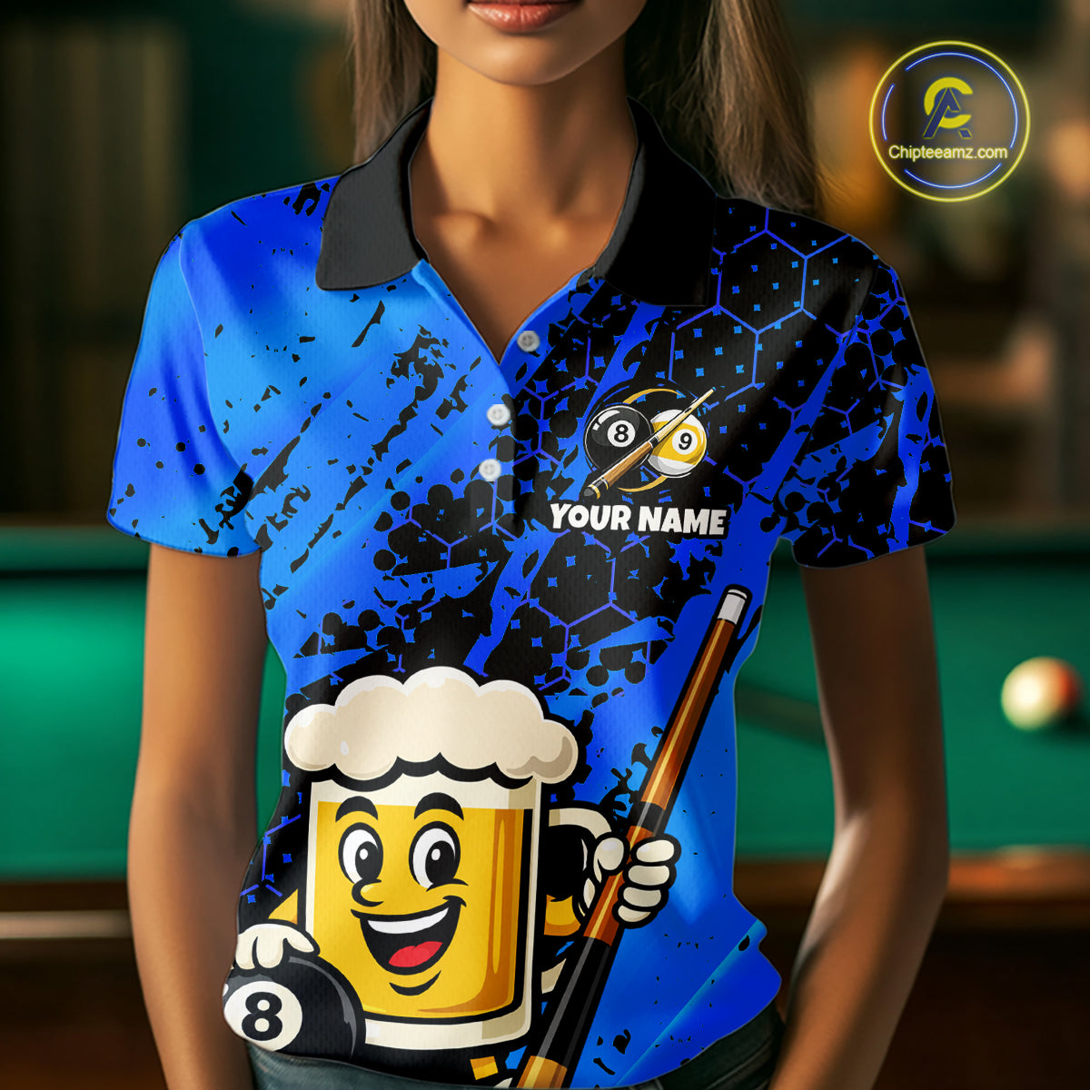 Woman wearing a bright blue billiards polo with black splatter graphics, custom “YOUR NAME” text, and a smiling beer mug mascot holding a pool cue.