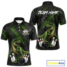 Load image into Gallery viewer, Front and back bowling polo shirt featuring a dinosaur standing among bowling pins and ball artwork on black green textured background.