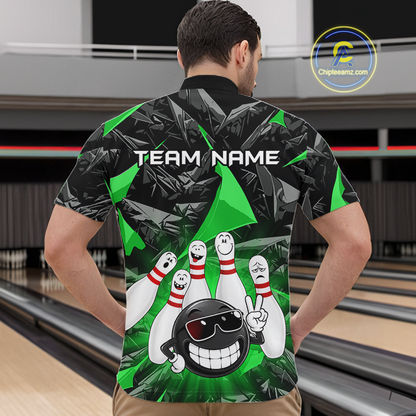 A man standing in a bowling alley wearing a short-sleeve bowling shirt from the back. The shirt features a black and green tropical leaf pattern with cartoon bowling pins, a bowling ball character, and the text 'TEAM NAME'.