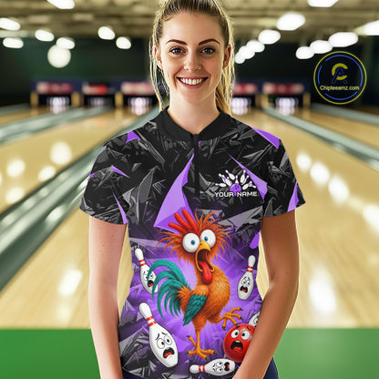 A woman wearing a short-sleeve bowling shirt with a cartoon rooster and bowling pins graphic, standing in front of a blurred bowling alley background. The shirt is black and purple with a colorful rooster design.