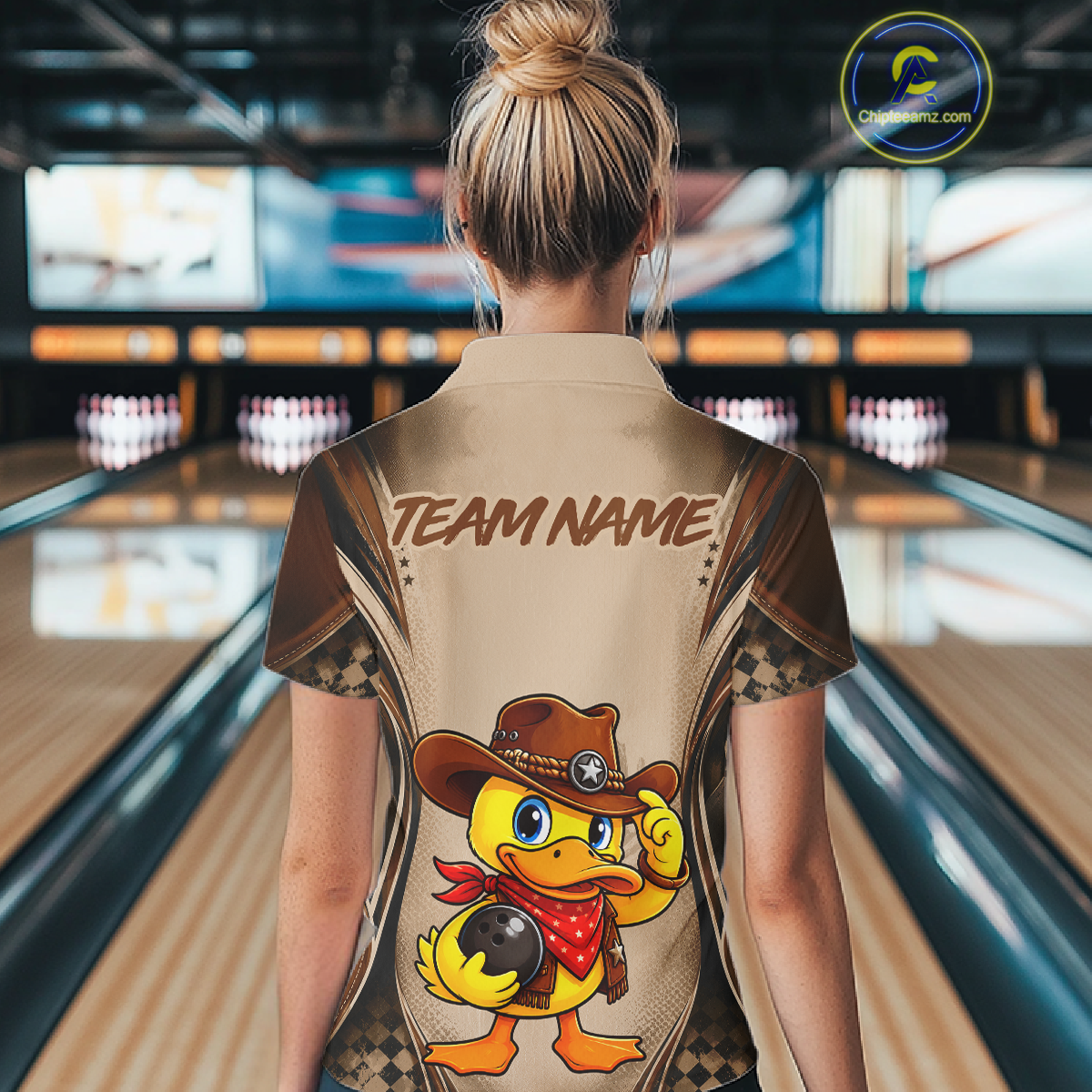 Person wearing a custom bowling shirt with a duck design and 'Team Name' text in a bowling alley.
