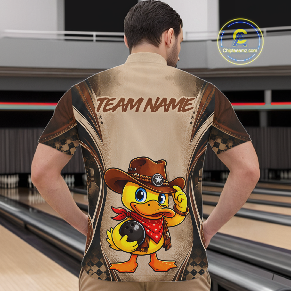 Person wearing a bowling shirt with a duck design and 'Team Name' text in a bowling alley.