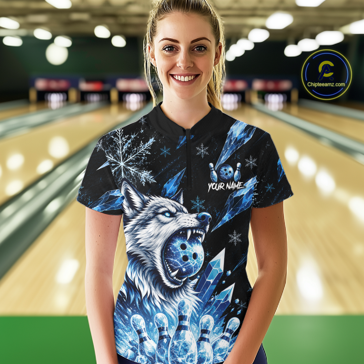 Woman wearing a black bowling shirt with a blue wolf design in a bowling alley.