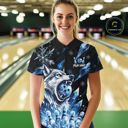 Woman wearing a black bowling shirt with a blue wolf design in a bowling alley.