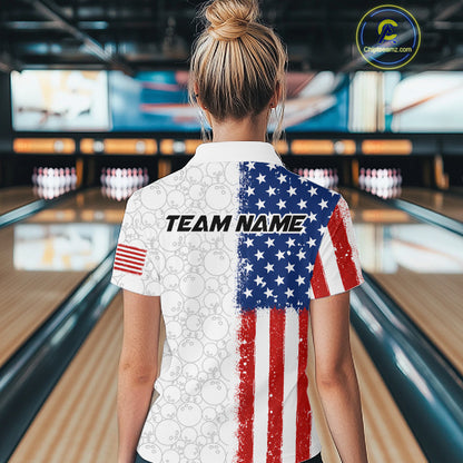A woman viewed from behind wearing a custom short-sleeve bowling shirt with an American flag design on a bowling alley background. The shirt features a distressed red, white, and blue flag pattern on the back, with 'TEAM NAME' printed across the center.