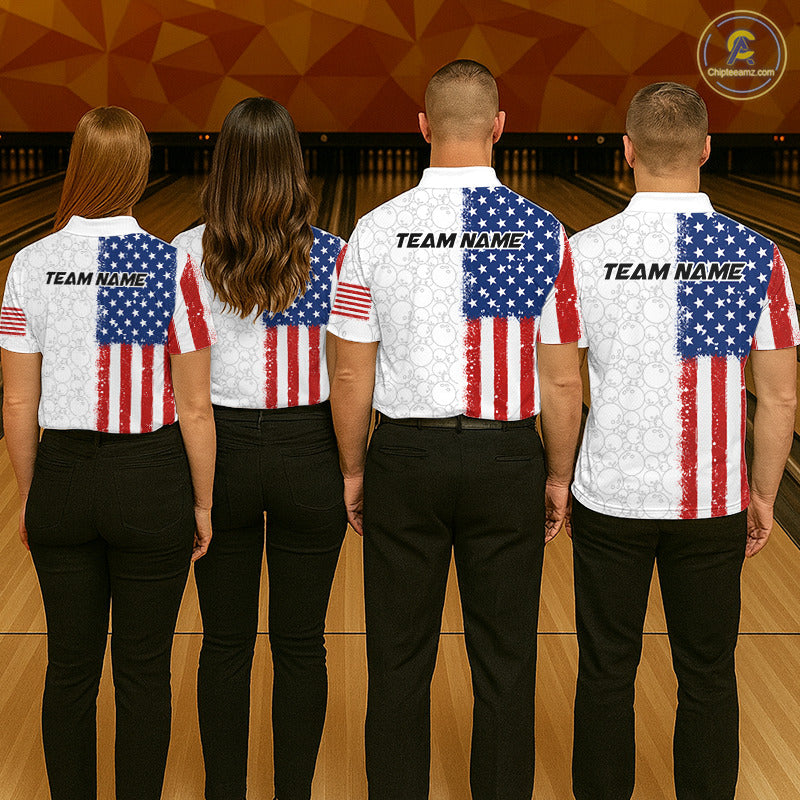 Four people standing in a bowling alley, shown from the back, wearing matching white bowling shirts with a distressed American flag print on the back and sleeves, paired with black pants. The shirts have 'TEAM NAME' printed across the upper back.