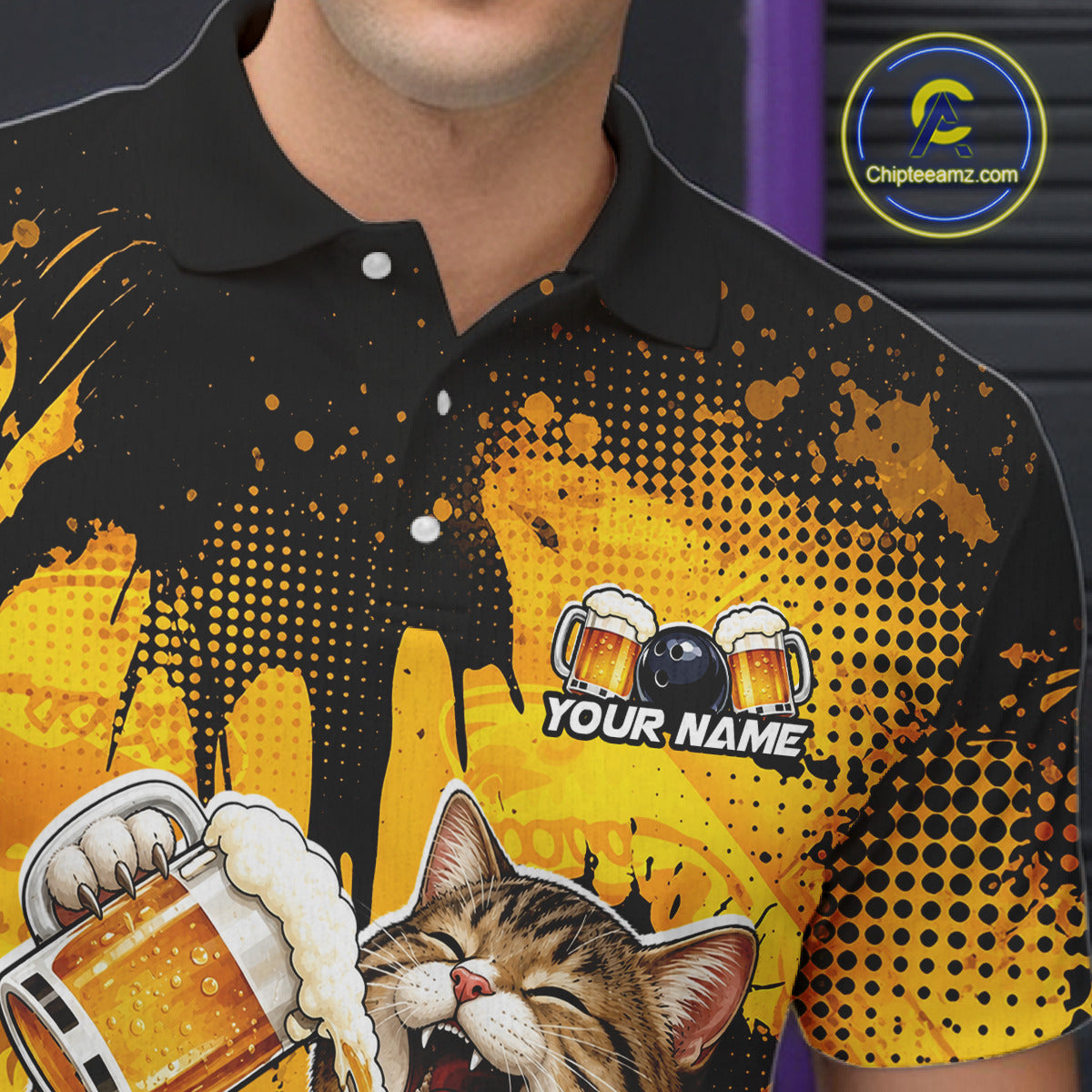 Person wearing a black and yellow polo shirt with a cat and beer design, featuring 'Chipleeamz.com' logo.