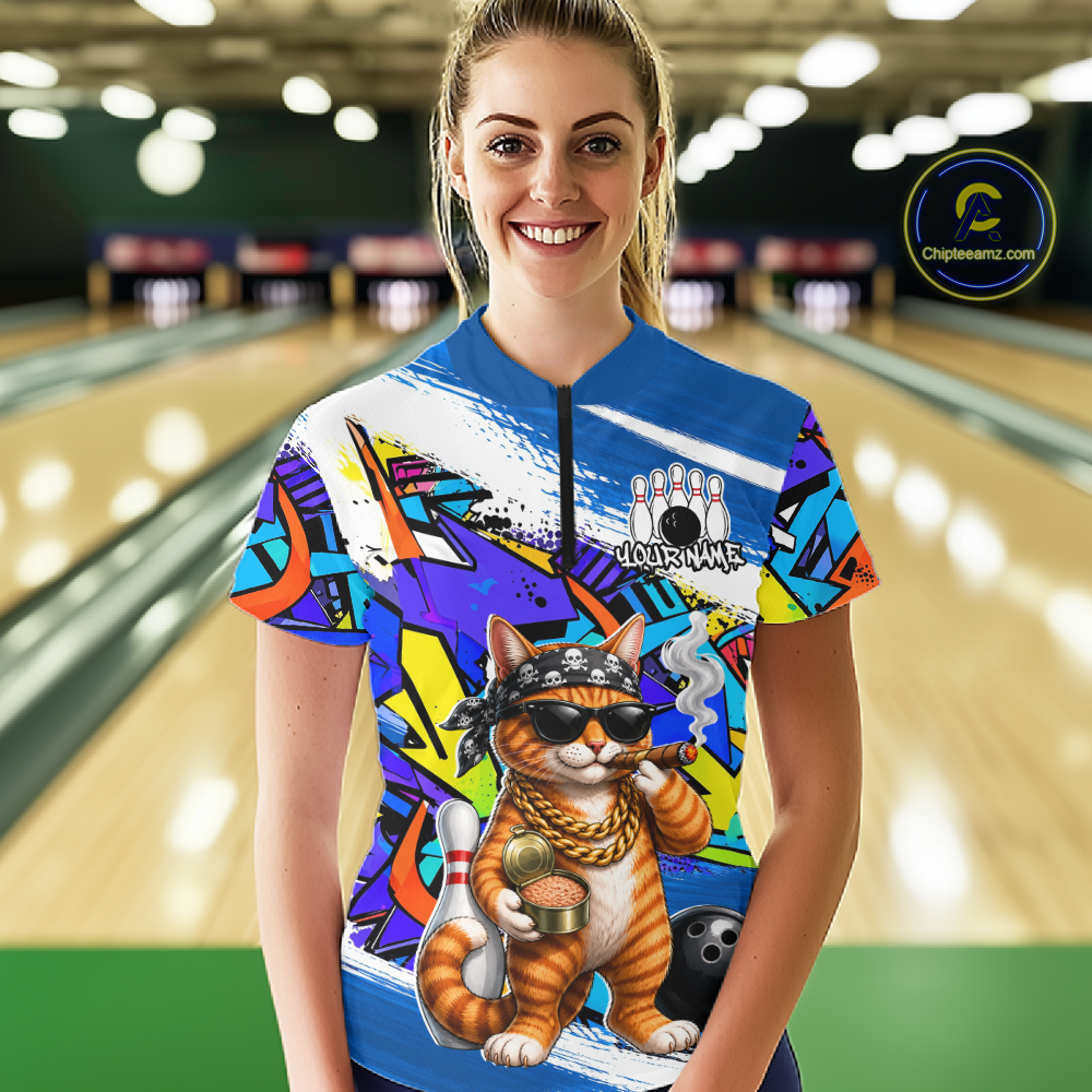Woman wearing a colorful bowling shirt with a cat design in a bowling alley.