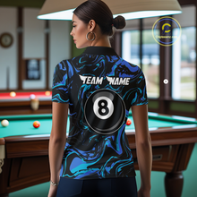 Load image into Gallery viewer, Back view of a woman wearing a black billiards polo with teal and turquoise marble swirls, “TEAM NAME” text, and a large 8-ball graphic.