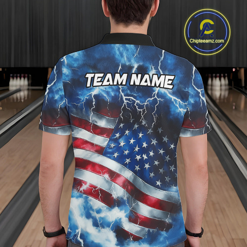 A man viewed from behind wearing a short-sleeve collared shirt with a patriotic American flag design featuring lightning and clouds, with the text 'TEAM NAME' printed across the upper back. The background shows a bowling alley with lanes and pins.