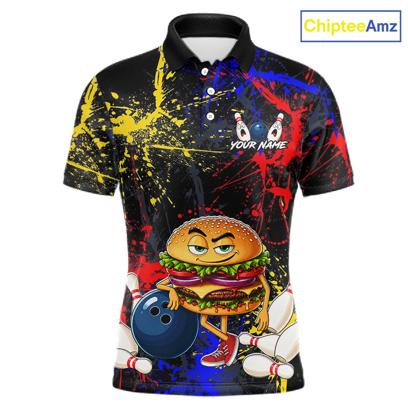 A short-sleeve polo shirt with a black base covered in colorful paint splatters and a cartoon bowling-themed burger character on the front. The shirt includes a black collar, white buttons, and a customizable text placeholder reading 'YOUR NAME' near the chest.