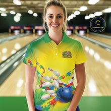 Load image into Gallery viewer, Female model inside a bowling center wearing green and yellow polo shirt, front view with autism puzzle bowling ball and pins design