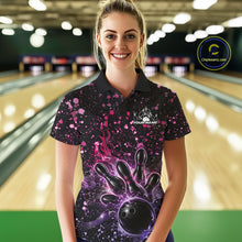 Load image into Gallery viewer, Female model wearing a black bowling polo shirt at the bowling lane with fiery bowling artwork and pink-purple paint splatter details.