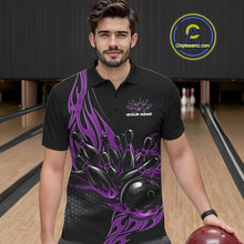 Load image into Gallery viewer, Male model seen from the front in a bowling lane wearing a black polo shirt featuring a purple flaming black bowling ball striking pins in a dynamic sports action design.