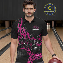 Load image into Gallery viewer, Male model seen from the front in a bowling lane wearing a black polo shirt featuring a pink flaming black bowling ball striking pins in a dynamic action scene.