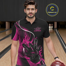 Load image into Gallery viewer, Male model seen from the front in a bowling lane wearing a black and pink polo shirt featuring a flame bowling ball striking pins in a dynamic sports action design.