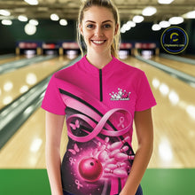 Load image into Gallery viewer, Female model wearing a pink bowling quarter zip with pink ribbon artwork, delicate butterflies, and bowling graphics at the bowling lane.