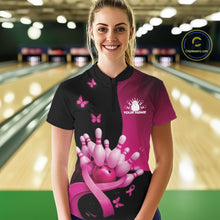 Load image into Gallery viewer, Front view of a female model in a black and pink bowling quarter zip featuring pink ribbon artwork, small butterflies, and bowling-themed accents at the bowling lane.