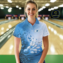 Load image into Gallery viewer, Front view of a female model in a white and blue bowling polo shirt featuring butterfly accents and bowling graphics at the bowling lane.