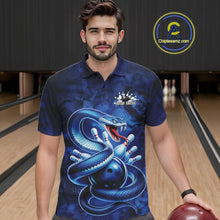 Load image into Gallery viewer, Male model wearing a bowling polo in a bowling lane with blue cobra graphics wrapped around a bowling ball.