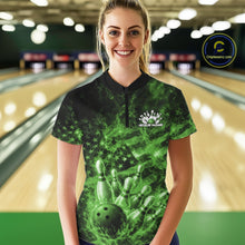Load image into Gallery viewer, Female model wearing a black and green bowling quarter-zip in a bowling lane with fiery bowling graphics and flag-inspired artwork.