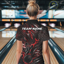 Load image into Gallery viewer, Back view of a female model in a bowling venue wearing a black and red polo shirt featuring a flaming bowling ball hitting the pins with flag-inspired graphics.