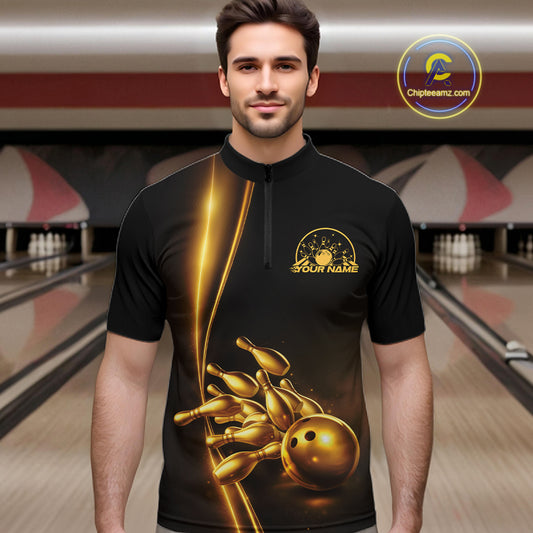 Front view of a male model in a bowling lane wearing a black quarter-zip shirt with golden bowling ball and pins artwork and refined bowling visuals.