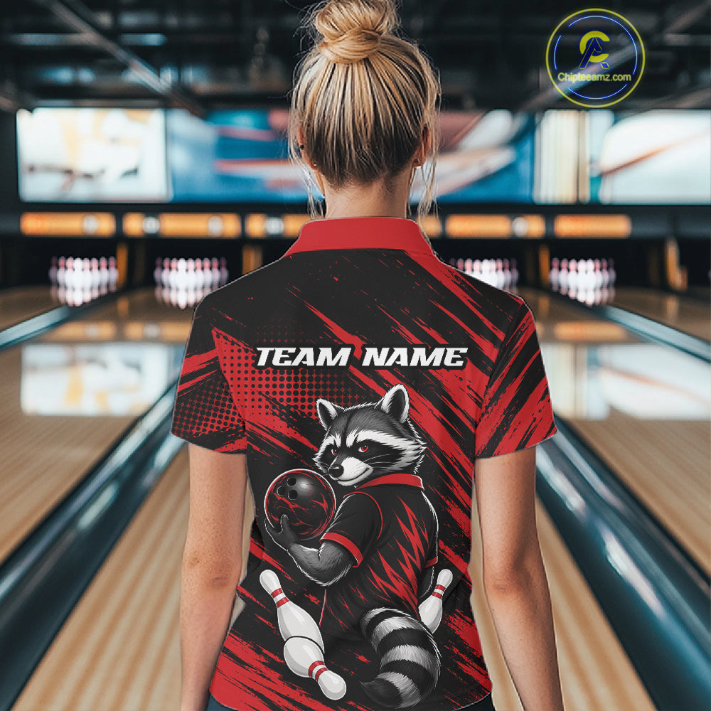 A woman viewed from behind wearing a short-sleeve bowling polo shirt with a raccoon graphic and 'TEAM NAME' text on the back, standing in a bowling alley.