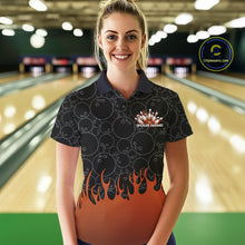 Load image into Gallery viewer, Front view of a female model in a bowling lane wearing a black polo shirt with vibrant orange flames and bowling ball pattern in a dynamic flaming bowling action design.