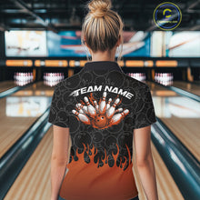 Load image into Gallery viewer, Back view of a female model in a bowling lane wearing a black polo shirt featuring vibrant orange flames and bowling ball pattern with bold athletic bowling graphics.