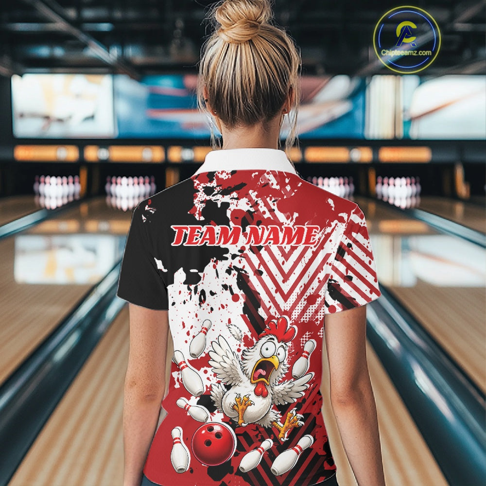 A woman viewed from behind wearing a short-sleeve bowling-themed graphic shirt in a bowling alley. The shirt features a split black and red design with white splatter, a cartoon chicken, bowling pins, and the text 'TEAM NAME' across the upper back.
