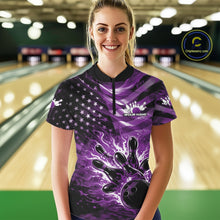Load image into Gallery viewer, Female model wearing a black bowling quarter-zip shirt at the lane featuring purple flame bowling artwork and flag-inspired details.