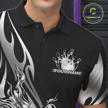 Load image into Gallery viewer, Close-up view of the left chest area of a black polo shirt showing a silver metal tribal flame bowling ball and pins design detail.